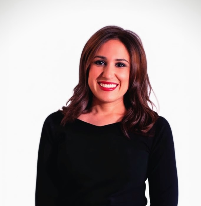 A professional woman in a modern office environment, representing Zeenia Irani.